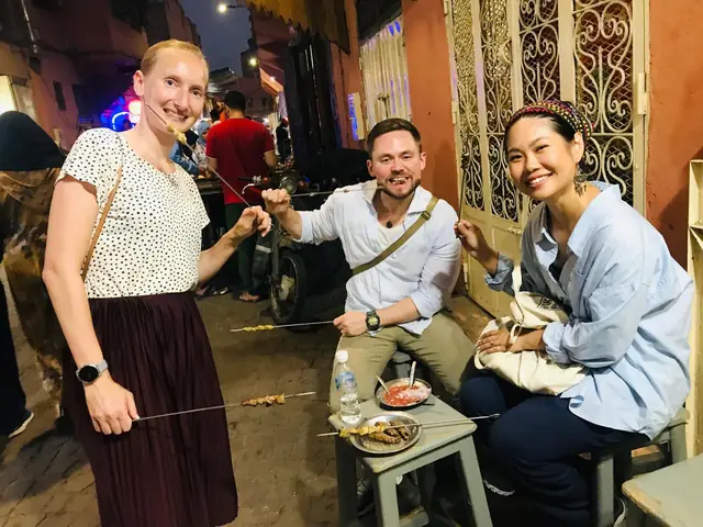 Three guests eating grilled skewers in a Medina street